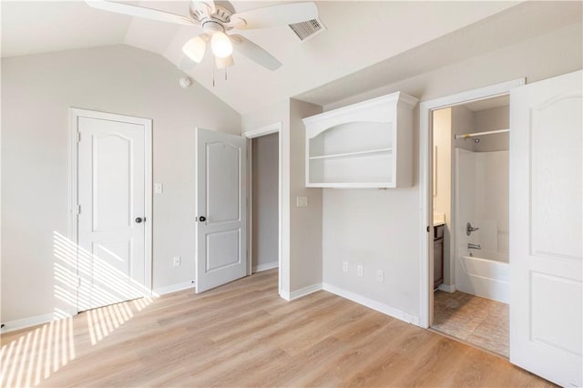 unfurnished bedroom featuring ensuite bathroom, ceiling fan, light wood-type flooring, and lofted ceiling