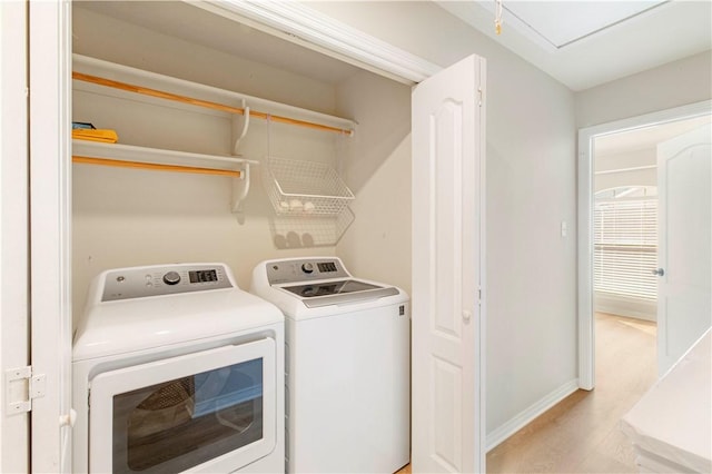 laundry area with washer and dryer and light hardwood / wood-style floors