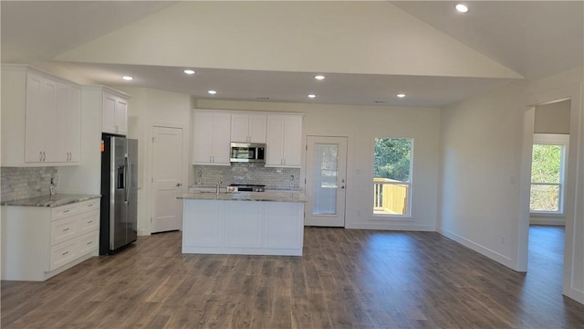 kitchen with a kitchen island with sink, vaulted ceiling, hardwood / wood-style flooring, white cabinetry, and stainless steel appliances