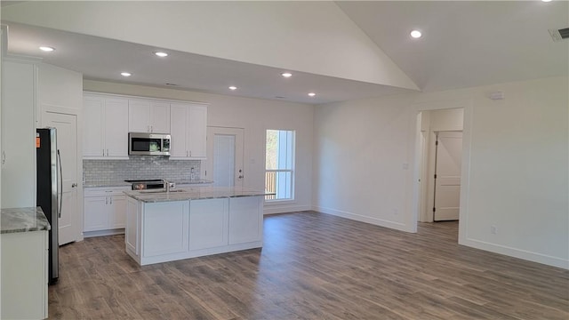 kitchen with white cabinets, stainless steel appliances, light hardwood / wood-style flooring, and a center island with sink