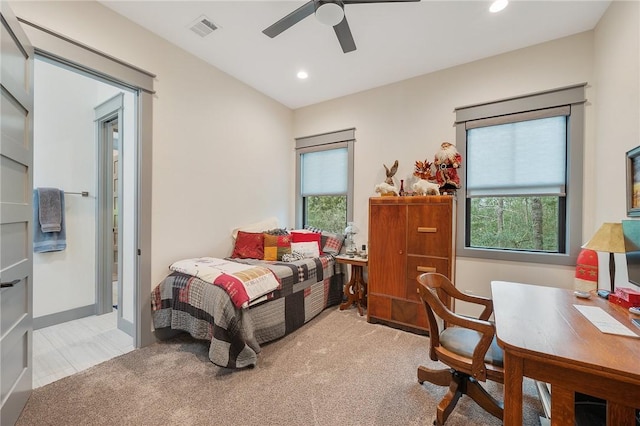 bedroom featuring multiple windows, light carpet, and ceiling fan