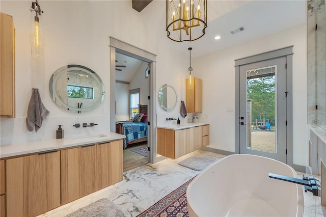 bathroom with a tub to relax in, decorative backsplash, vaulted ceiling, a chandelier, and vanity