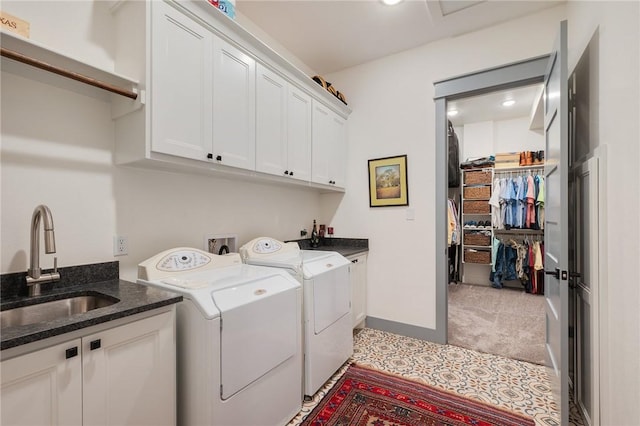 washroom with sink, cabinets, separate washer and dryer, and light colored carpet