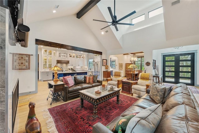 living room featuring french doors, light hardwood / wood-style floors, ceiling fan, high vaulted ceiling, and beamed ceiling