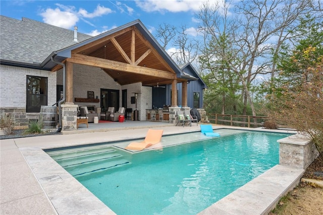 back of property with a fenced in pool and a patio area