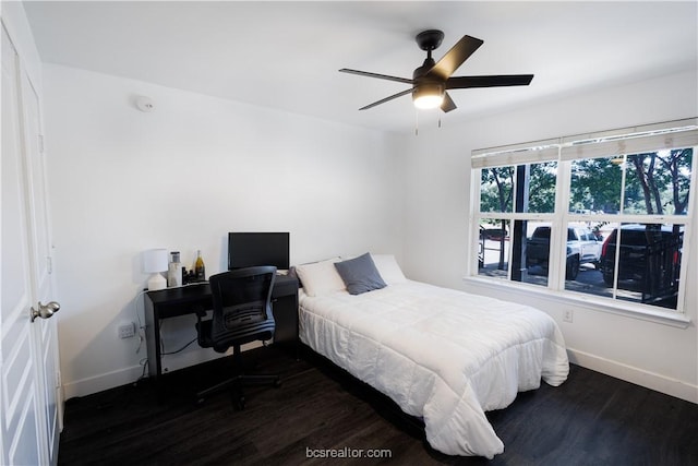 bedroom with dark hardwood / wood-style floors and ceiling fan