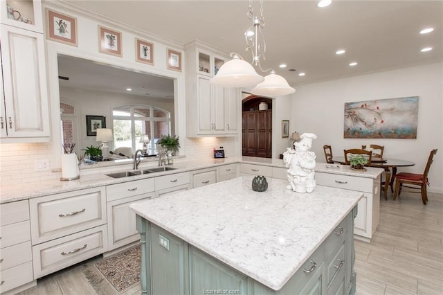 kitchen featuring white cabinets, a kitchen island, and sink