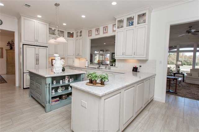 kitchen featuring kitchen peninsula, white cabinetry, hanging light fixtures, and light stone counters