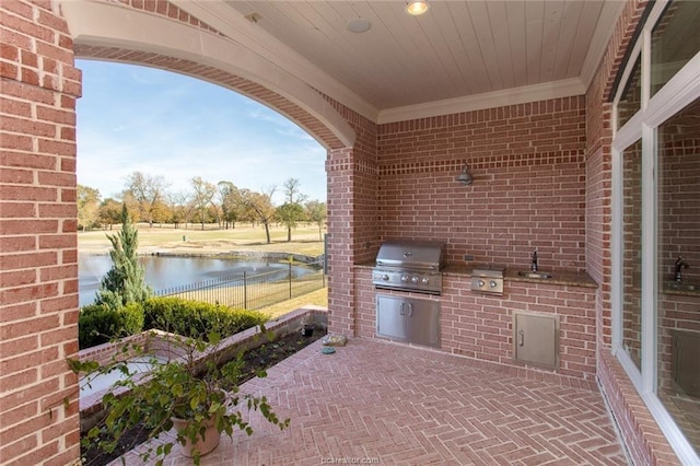 view of patio with area for grilling and a water view