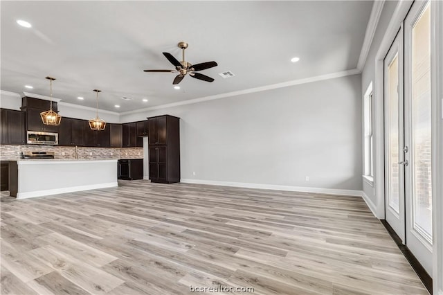 unfurnished living room with ceiling fan, ornamental molding, and light hardwood / wood-style flooring