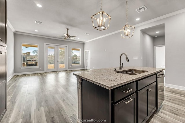 kitchen featuring a center island with sink, plenty of natural light, sink, and ceiling fan with notable chandelier