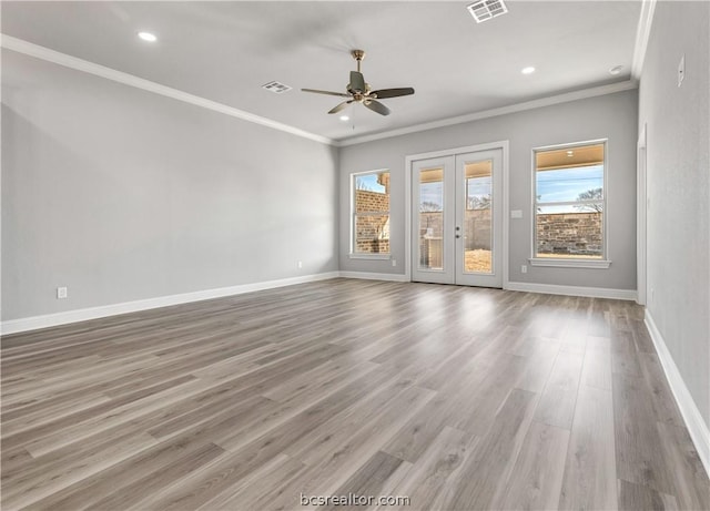 empty room featuring ceiling fan, french doors, ornamental molding, and hardwood / wood-style flooring