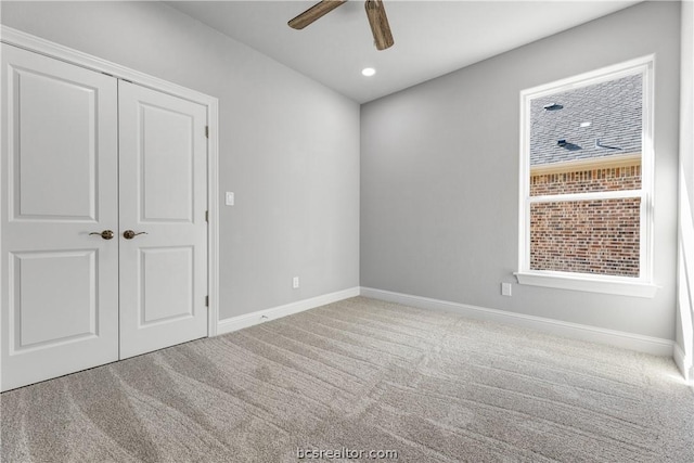 carpeted spare room with ceiling fan