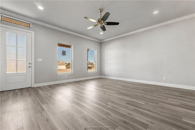 spare room with crown molding, hardwood / wood-style floors, and a healthy amount of sunlight