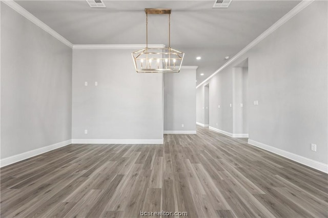 empty room with hardwood / wood-style floors, an inviting chandelier, and ornamental molding