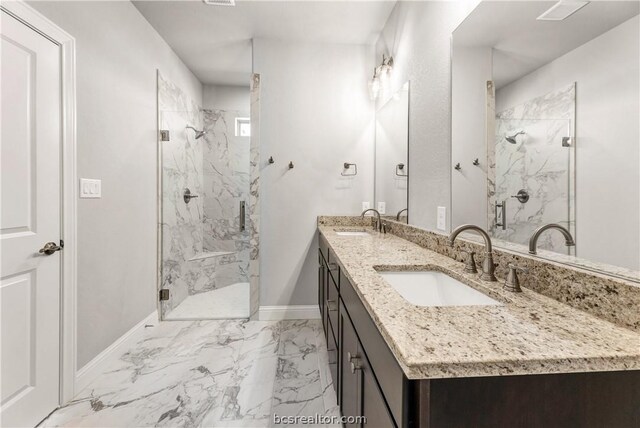 bathroom featuring a shower with door and vanity