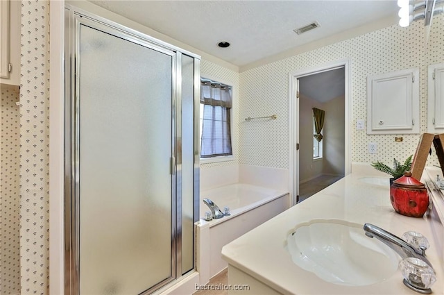 bathroom with vanity, separate shower and tub, and a textured ceiling