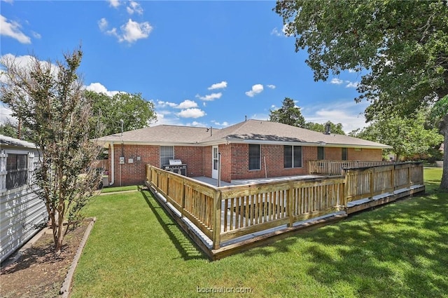 rear view of house with a yard and a wooden deck