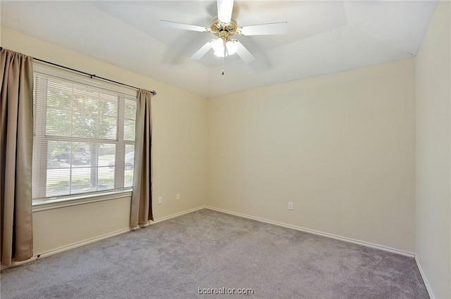 carpeted spare room featuring ceiling fan