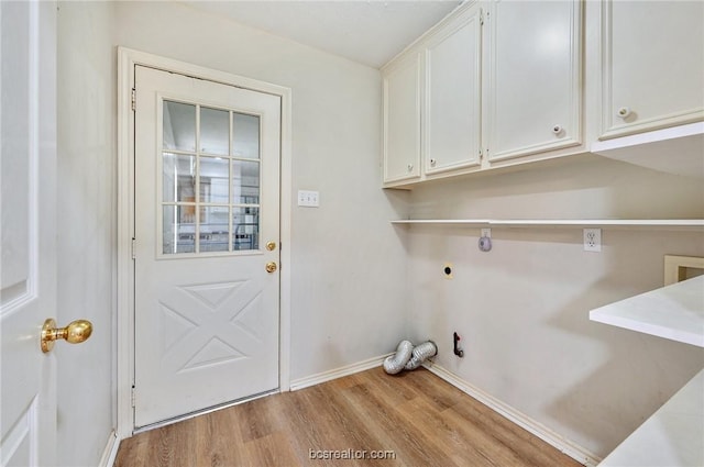 laundry area featuring hookup for an electric dryer, hookup for a gas dryer, light hardwood / wood-style floors, and cabinets