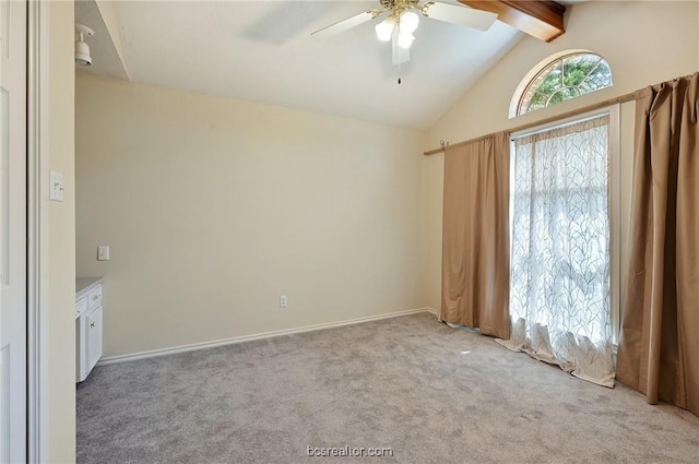 spare room featuring light carpet, ceiling fan, and lofted ceiling with beams