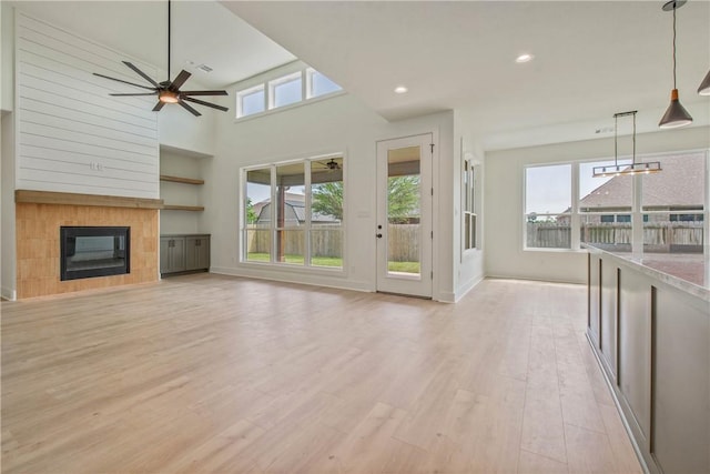 3034 Teller Dr, Bryan, TX 77808 - unfurnished living room with plenty of natural light, a tile fireplace, light wood finished floors, baseboards, and recessed lighting