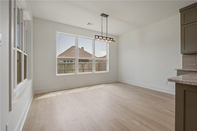 3034 Teller Dr, Bryan, TX 77808 - unfurnished dining area featuring light wood-style floors and baseboards