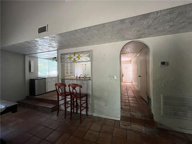 dining room featuring a textured ceiling and dark tile patterned floors