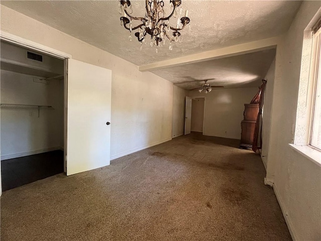 unfurnished living room featuring carpet flooring, ceiling fan with notable chandelier, and a textured ceiling