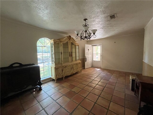 dining space featuring tile patterned floors, crown molding, a textured ceiling, and a notable chandelier