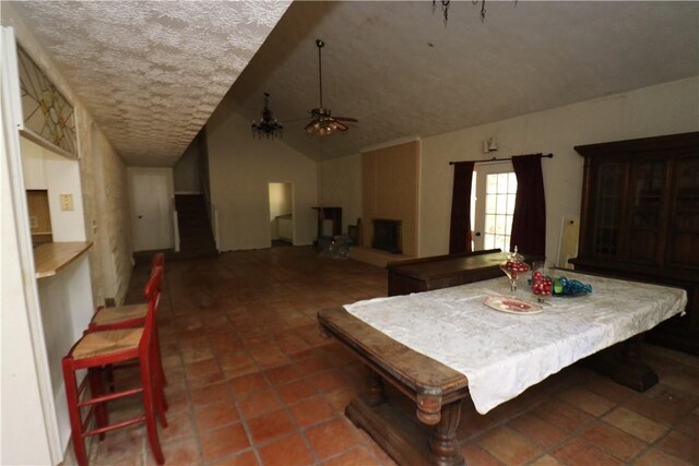 dining room with a textured ceiling, ceiling fan, and lofted ceiling