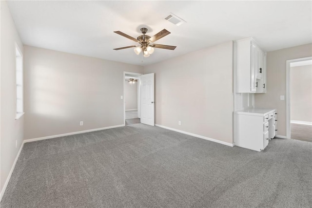 spare room with ceiling fan, carpet flooring, and a wealth of natural light