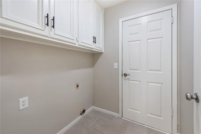 laundry room with cabinets, light tile patterned flooring, and hookup for an electric dryer