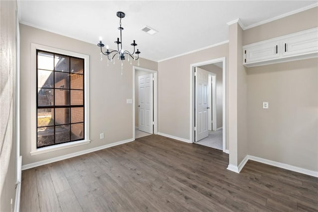 unfurnished dining area with dark wood-type flooring, ornamental molding, and a notable chandelier