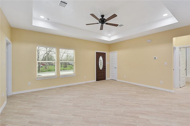 entrance foyer featuring ceiling fan, a raised ceiling, and light hardwood / wood-style floors