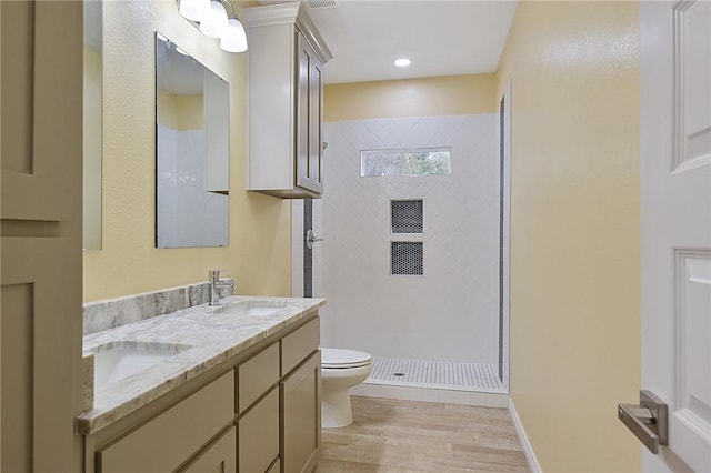 bathroom with vanity, hardwood / wood-style flooring, toilet, and walk in shower