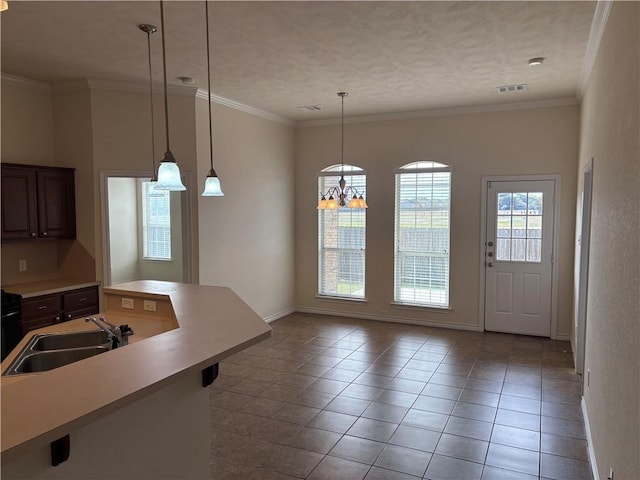 kitchen with sink, hanging light fixtures, light tile patterned floors, dark brown cabinets, and a chandelier