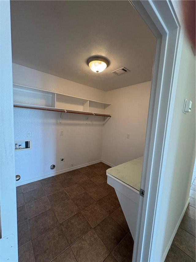 washroom featuring dark tile patterned flooring, electric dryer hookup, and hookup for a washing machine