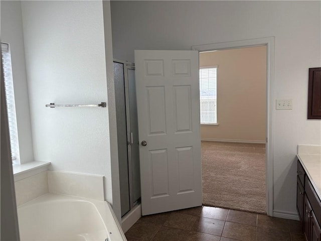 bathroom featuring tile patterned floors, vanity, and shower with separate bathtub