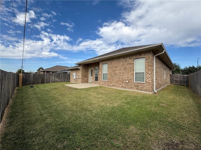 rear view of property featuring a lawn and a patio