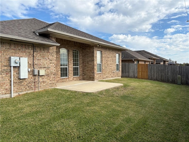 back of house with a yard and a patio