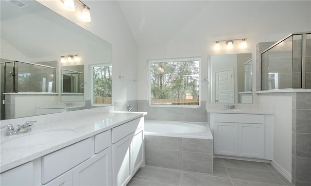 bathroom with plus walk in shower, tile patterned flooring, vaulted ceiling, and vanity