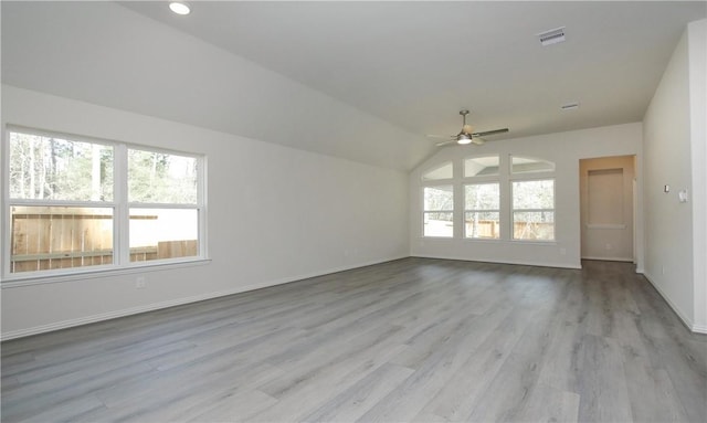 unfurnished room with ceiling fan, vaulted ceiling, and light wood-type flooring