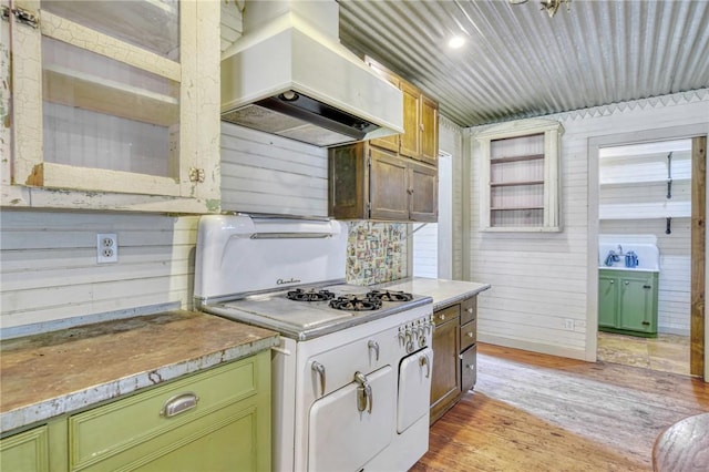 23405 Martha Williams Rd, Montgomery, TX 77356 - kitchen featuring premium range hood, light wood-style flooring, wood walls, light countertops, and green cabinets