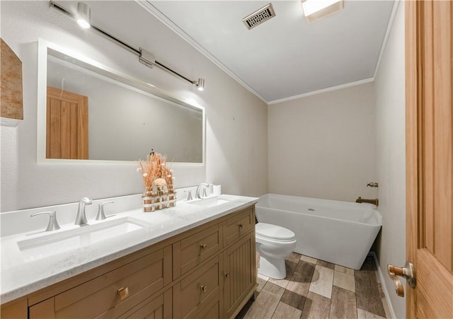 206 22 Hills Rd, Gause, TX 77857 - full bathroom featuring a freestanding bath, crown molding, double vanity, and wood finished floors
