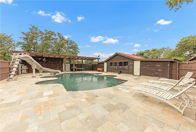 206 22 Hills Rd, Gause, TX 77857 - view of pool with a water slide, a fenced backyard, a patio area, an outbuilding, and a storage structure