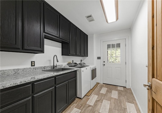206 22 Hills Rd, Gause, TX 77857 - laundry area featuring washer and dryer, cabinet space, and light wood-style flooring