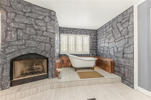 206 22 Hills Rd, Gause, TX 77857 - full bath with a freestanding bath, wood finished floors, and a fireplace
