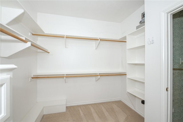 walk in closet featuring light colored carpet