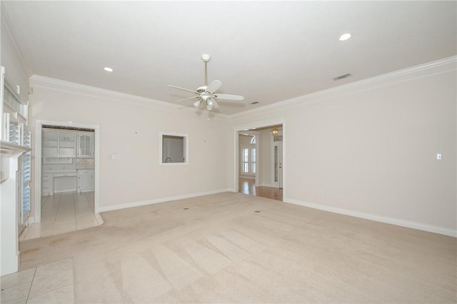 empty room featuring light carpet, ceiling fan, and crown molding